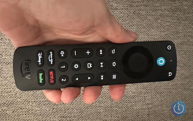 Amazon Alexa Voice Remote Pro in hand with backlight on.