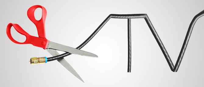 Concept photo showing a pair of scissors cutting a coaxial cable shaped to form the word TV