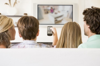 Family watching TV on couch