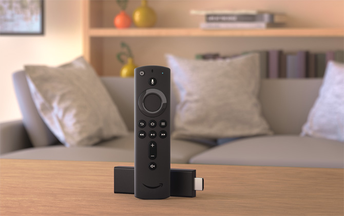 Fire TV Stick on table with sofa and bookshelf in the background