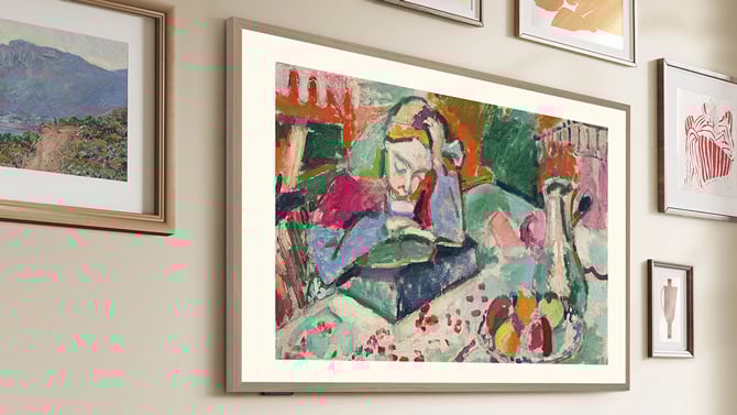 Hisense CanvasTV shown hanging on a wall with framed artwork
