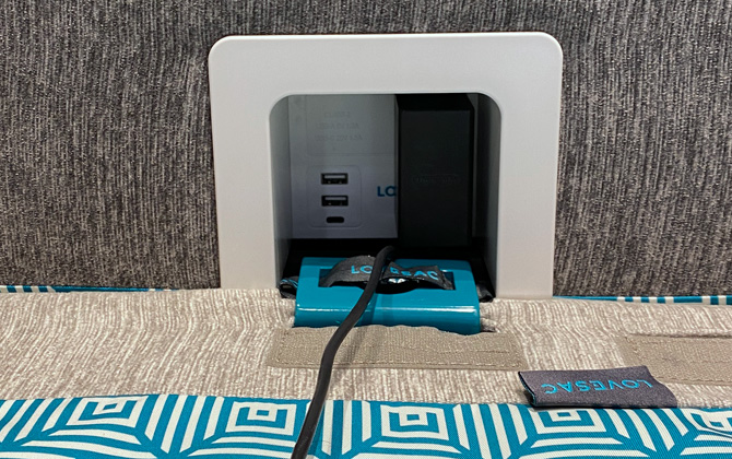 Lovesac Power Hub with a black power brick plugged into the outlet on the right and the two USB-A and USB-C ports free. 