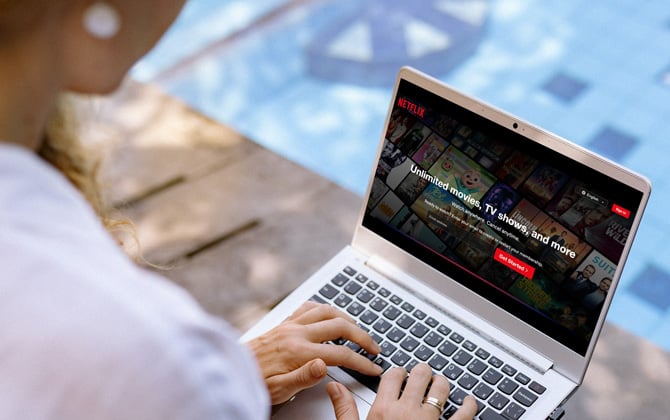 Laptop shown poolside with the Netflix sign-in screen.