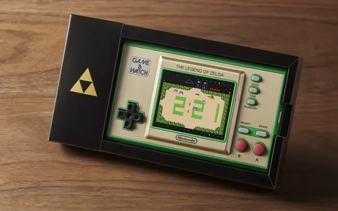 Nintendo Game & Watch: Legend of Zelda gaming system on wooden surface.