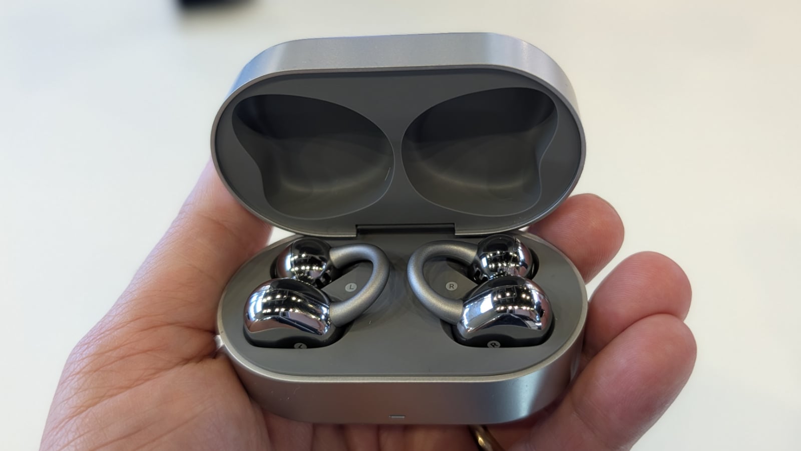 Noise Master Buds Open earbuds and case held in hand