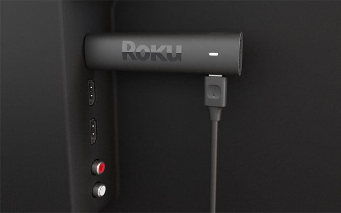 Roku Streaming Stick 4k Plus plugged into an HDMI port with two additional HDMI ports below and red and white audio jacks.