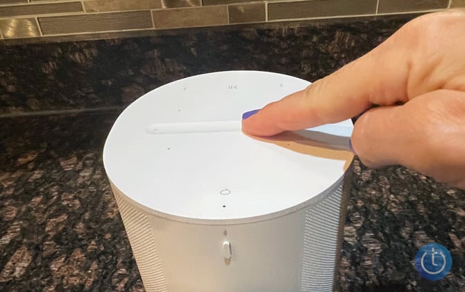 Top of the Sonos Era 100 with a hand pointing out the touch controls.