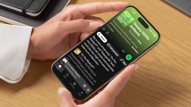 Hands holding a cellphone with the Spotify Prompt playlist showing