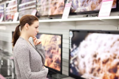 Woman looking at TVs