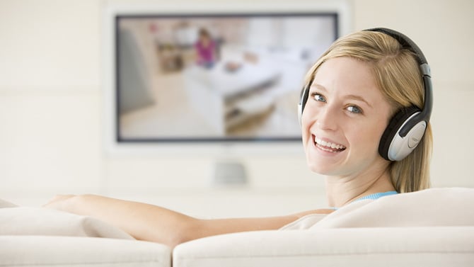 Woman watching TV with wireless headphones.