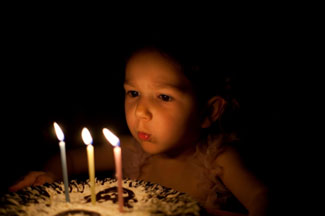 child blowing out candles