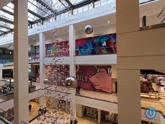 Image taken by GoPro Hero10 with ISO 100 and saved in the camera as a JPEG. The scene is looking down and across a mall courtyard with a reflective ball art installation hanging down from the ceiling.