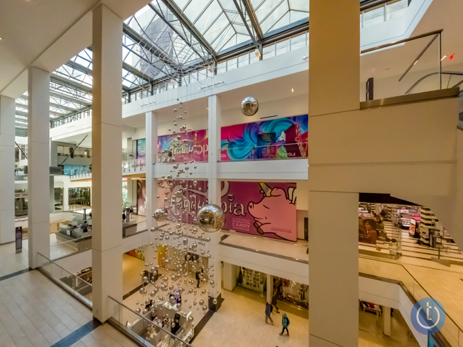 Image taken by GoPro Hero10 with ISO 1600 and saved in the camera as a RAW file. The scene is looking down and across a mall courtyard with a reflective ball art installation hanging down from the ceiling.