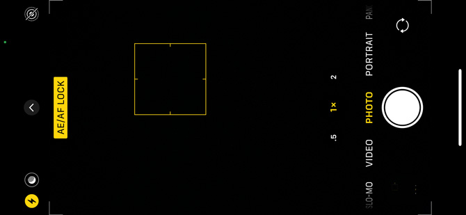 iOS 14 Camera app screenshot showing AE/AF lock label in a yellow box and a yellow-box outline showing the locked area on a black screen