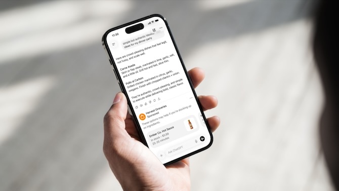 Hand holding a phone showing ChatGPT on the screen.
