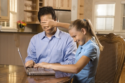 Girl hides father's eyes from computer screen