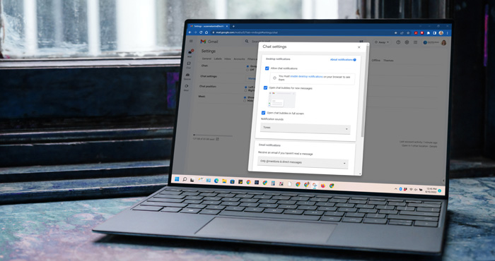 Gmail chat settings on a Windows laptop on a desk near a window.