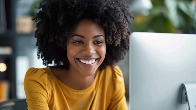 Happy woman looking at a computer monitor