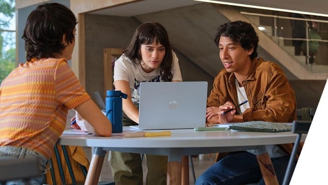 hp omnibook 5 16-inch on a table with three people at it