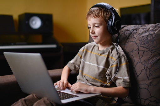 Boy using a laptop with headphones