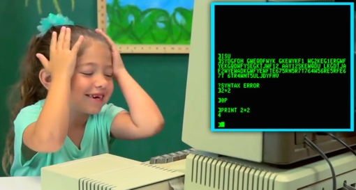 A young girl reacts to an old monochrome computer