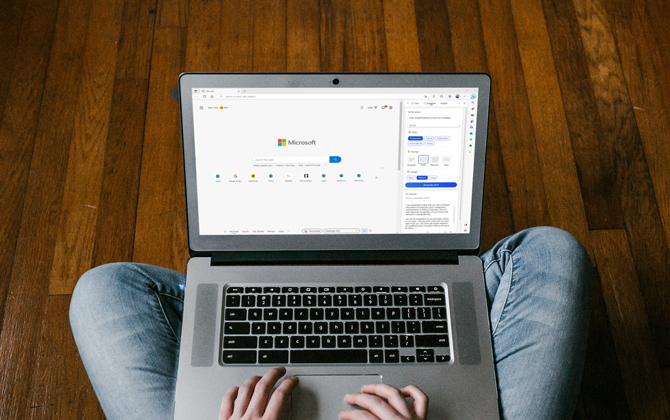 Person sitting on wood floor with laptop on their lap. The screen shows the Microsoft Edge Home Screen with the Bing Compose sidebar open.