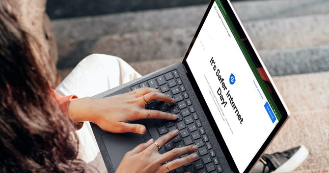 Woman using laptop with a screenshot of Google Password Manager in a Chrome browser with the words Safer Internet Day.