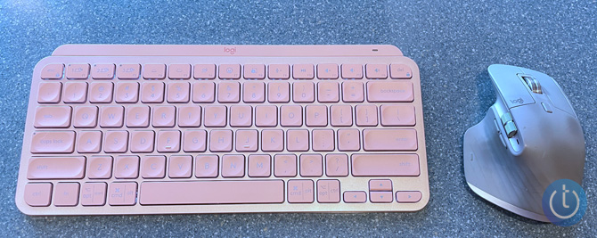 Logitech MX Mini in pink on gray desktop with Logitech MX Master 3 mouse.