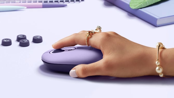 Logitech POP Mouse held in a hand on a desk