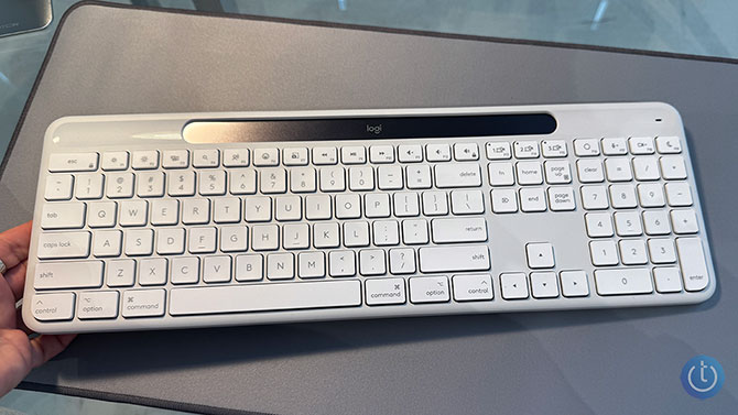 The Logitech Signature Slim Solar Plus keyboard is tilted with one hand.