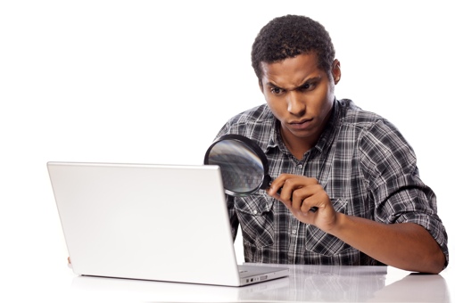 Man at computer with magnifying glass