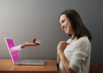 Woman handed wedding ring at computer