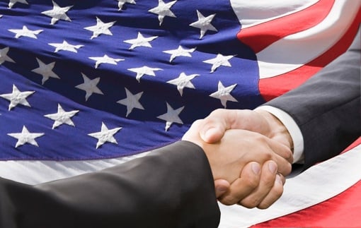 Handshake with American flag backdrop