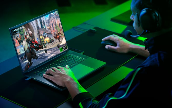 Hands on a laptop with the screen displaying Overwatch 2