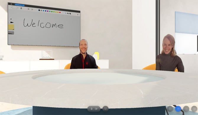 Room3D screenshot showing virtual whiteboard with the word welcom and two people at a conference room table. There are video chat menu icons at the bottom. 