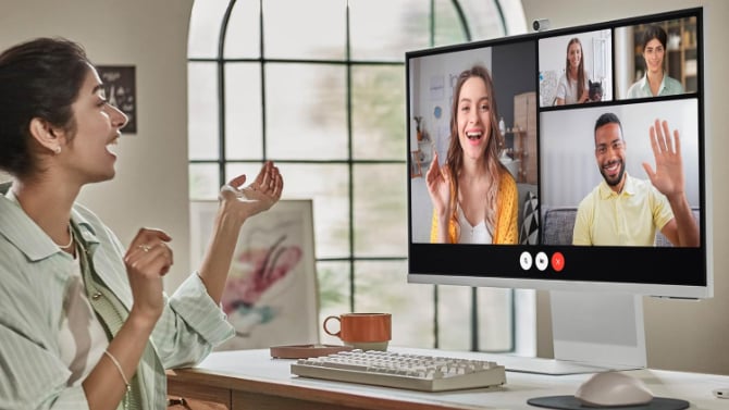 Samsung M8 monitor on desk setup with a video call on it
