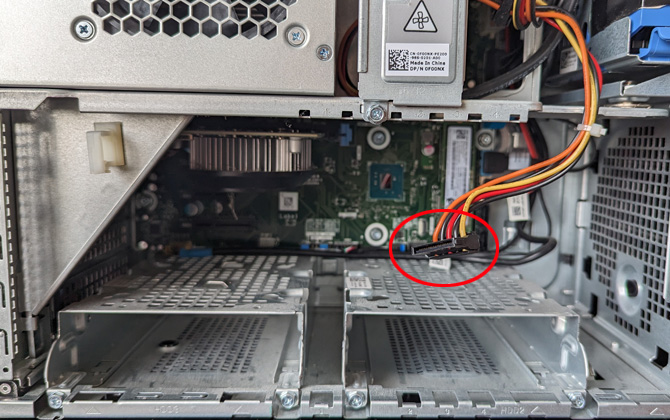 Interior of desktop computer. A free power cable is circled in red.