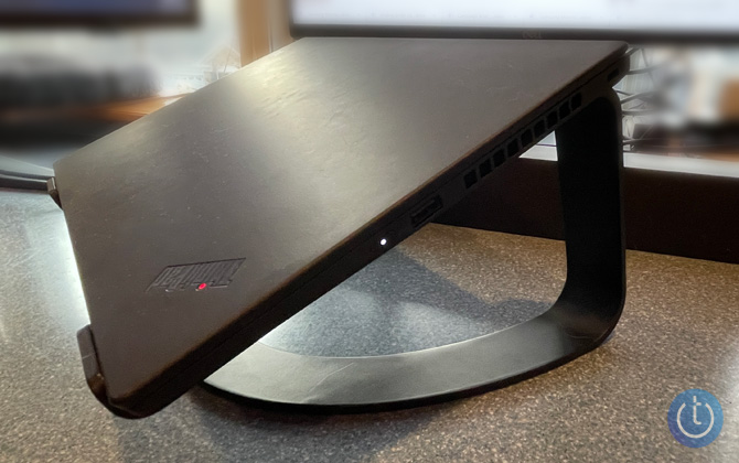 Twelve South Curve laptop stand with black Lenovo ThinkPad laptop on top. Background is blurred out