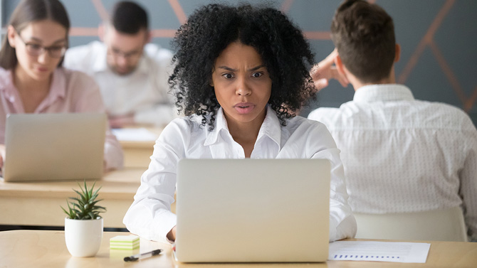 A woman looks shocked when she reads an email.