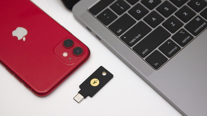 Yubico Yubikey 5 NFC with iPhone and MacBook on a white surface