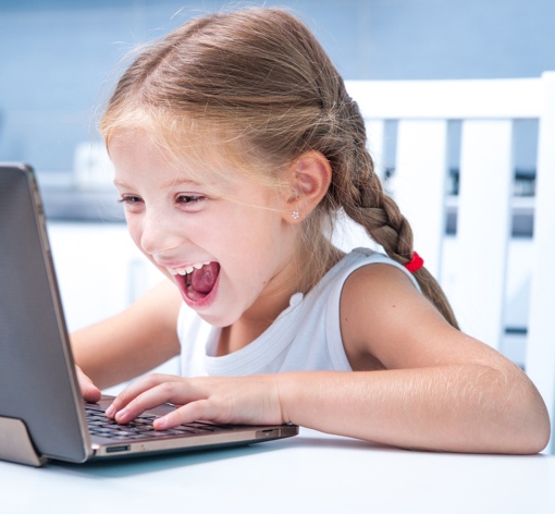 Child happily using a laptop