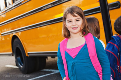 girl getting on school bus