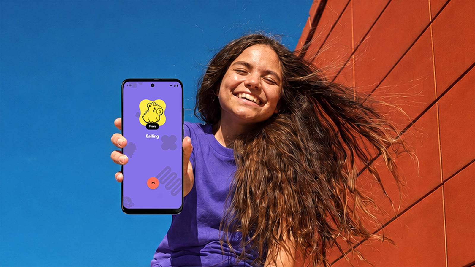 Smiling girl holding a Yello! phone displaying an incoming call from Finny on a purple screen.