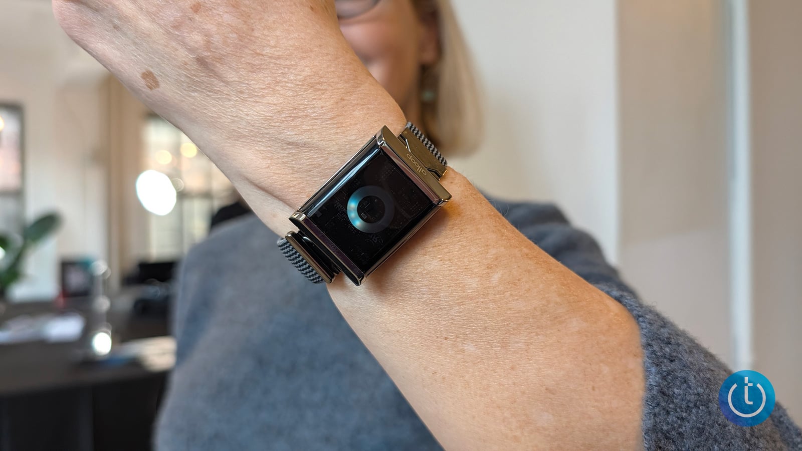The Alloop Trio is shown worn on a wrist with the Halo. There is a blue ring glowing on the Halo.