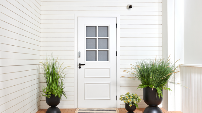 Frontof a white house with Aqara security camera and doorbell