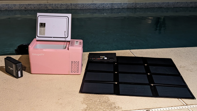 Paso 100W CIGS Portable Solar Blanket, JuiceGo 240Wh Portable Power Station, and 12V 23 Quart Mini Fridge next to a pool