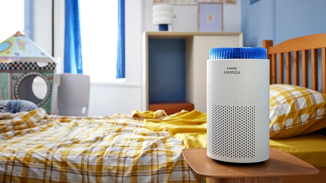 Coway Airmega 50 sits on a nightstand for scale.