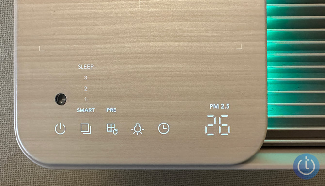 Coway Airmega Icon touch controls revealed against the wood surface. 