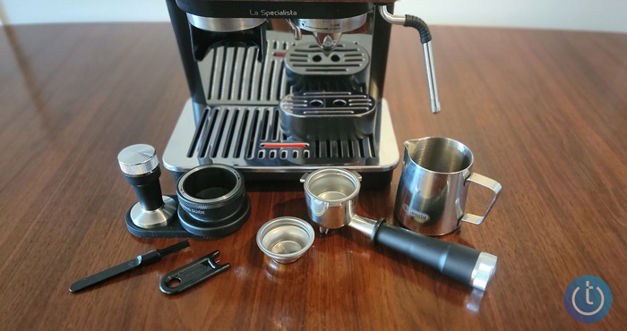 DeLonghi La Specialista Arte accessories: dosing funnel, tamper, and a mat to hold the filter while you're tamping, milk frother, single-shot basket, double-shot basket, portafilter, cleaning brush, and cleaning tool for milk frother. 