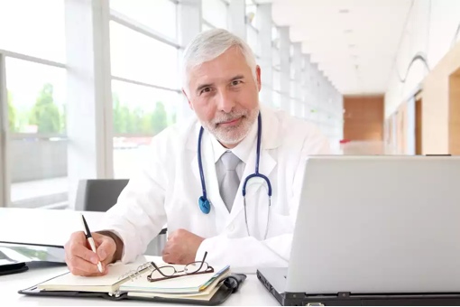 Doctor sitting at computer practicing telemedicine